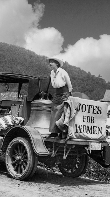 Woman stands next to the Justice Bell in support of voting rights