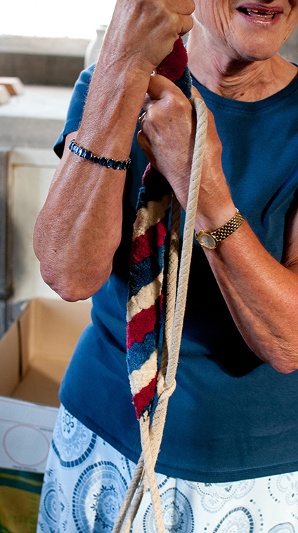 Woman pulls a rope to ring a bell