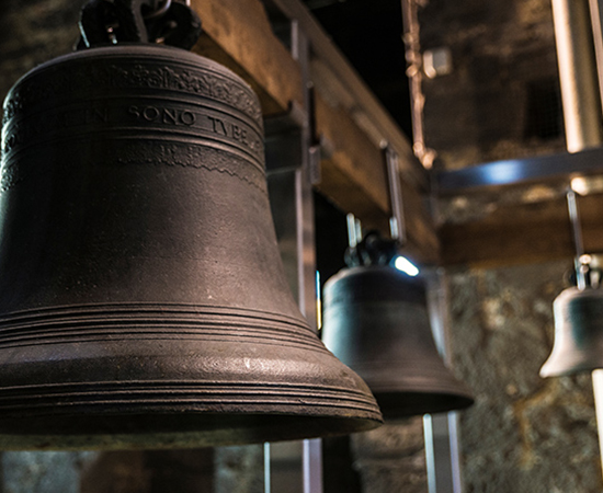Three bells hang within a belfry.