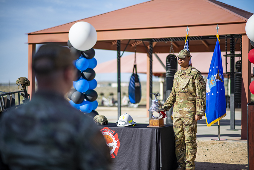 Airman Jonas Chattmon rings the bell traditionally signifying the loss of a firefighter's life