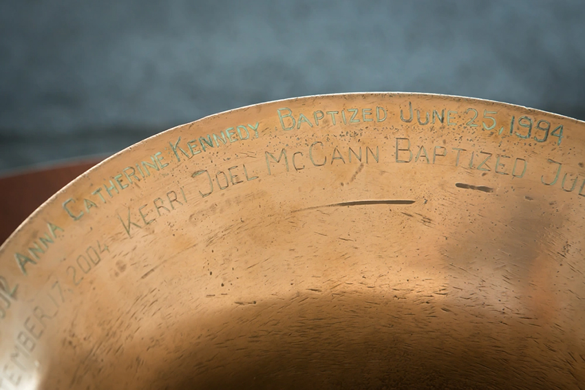Ship's bell showing the names and dates of those baptized within