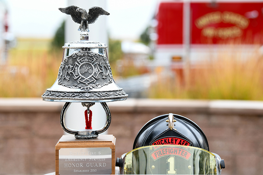A bell and a firefighter helmet sit on display at the 9/11 Patriot Day ceremony