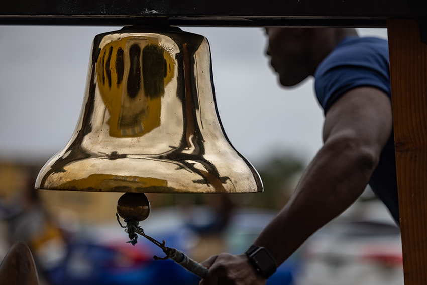 A U.S. Marine Corps Drill Master rings a bell during a motivational run