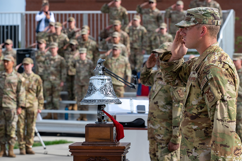 U.S. Air Force Staff Sgt. Jason Helgeson salutes behind a bell while the national anthem plays on Sept. 11