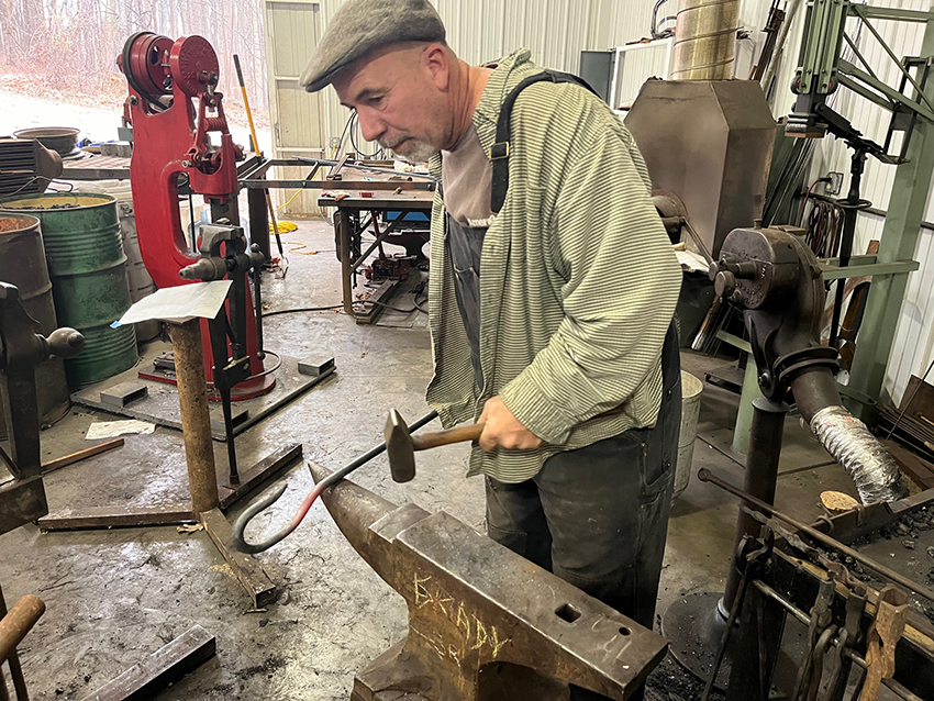 Blacksmith makes a hook for a bell