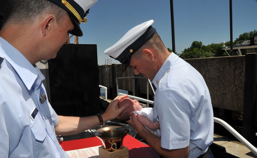 An infant is baptized in a ship's bell