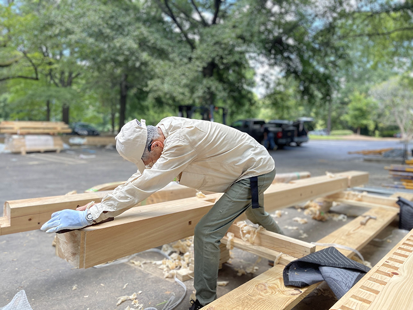 Master carpenter Noritaka Kondo from Hiroshima planes a beam of wood for the Peace Bell Tower