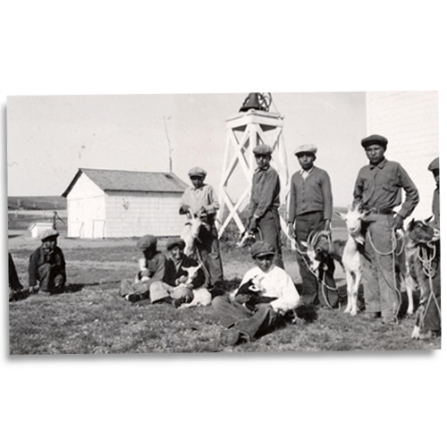 Youth from the Oglala tribe in a goat club, April 1937, with an alert bell rising above the South Dakota plains.