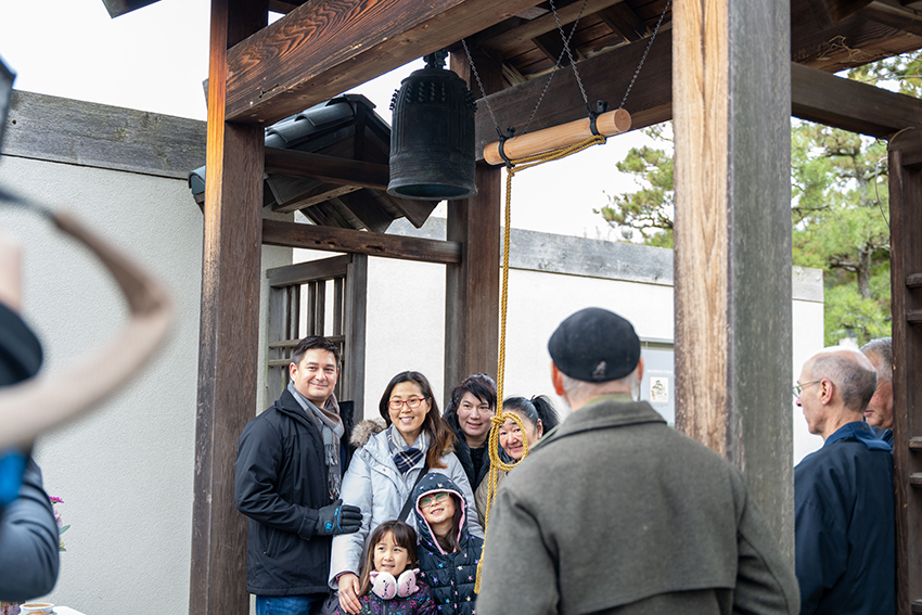 Festivalgoers stop for a photo beneath the 1798 hanshō installed at the National Bonsai & Penjing Museum within the U.S. National Arboretum during the National Bell Festival