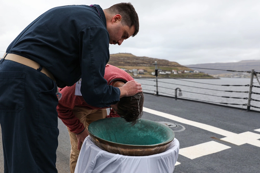 U.S. Navy Hospital Corpsman is baptized in the ship's bell