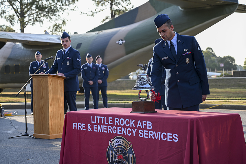 An Airman from the 19th Civil Engineer Squadron Fire Department rings a bell in honor of fallen firefighters during a 9/11 remembrance ceremony